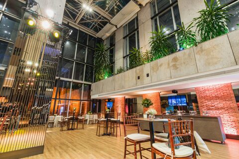 A modern industrial event venue with stage lighting.